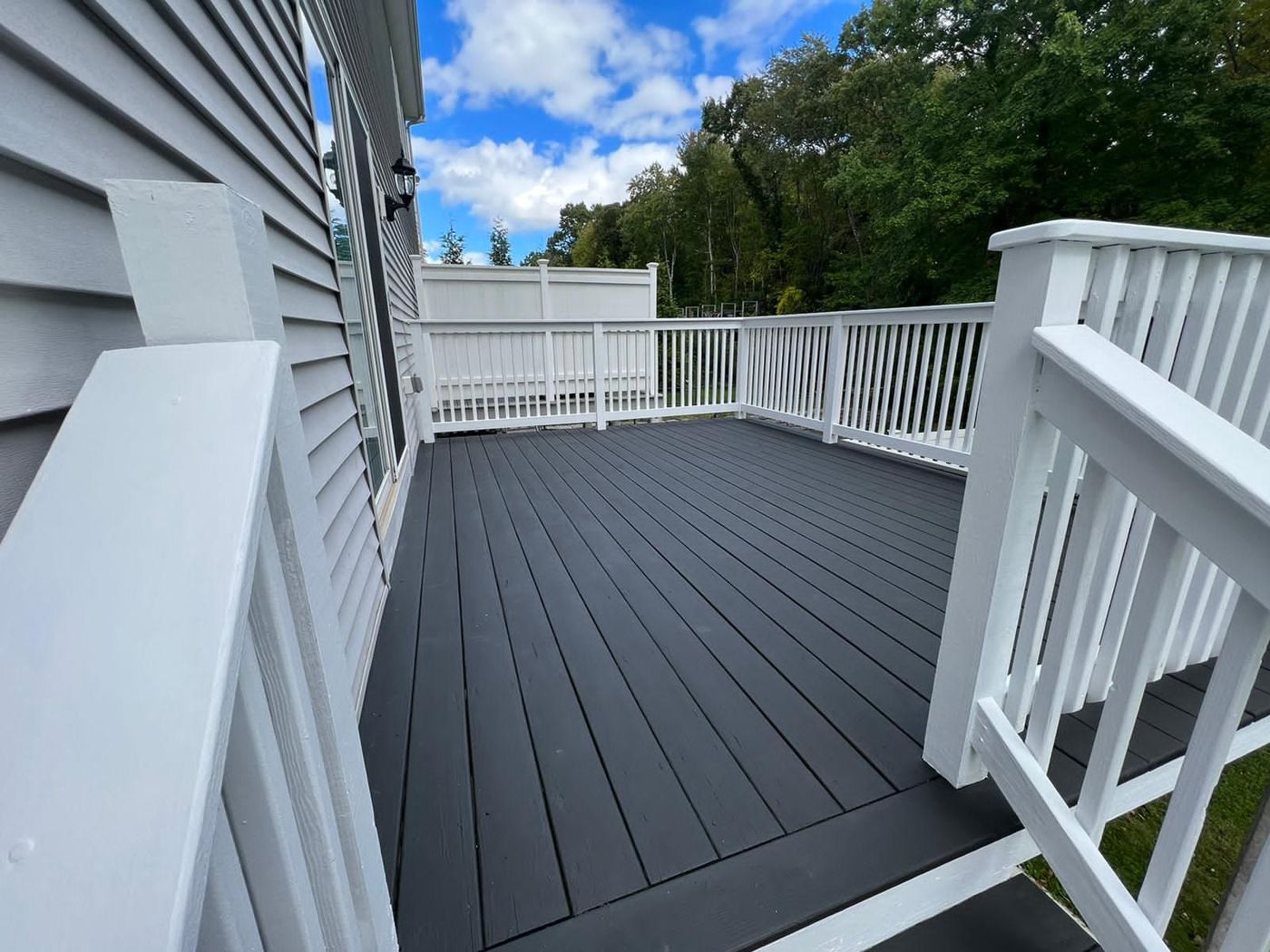 Freshly stained gray deck with white railings