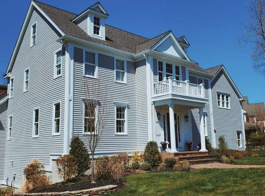 Gray colonial home with crisp white trim after an exterior repaint