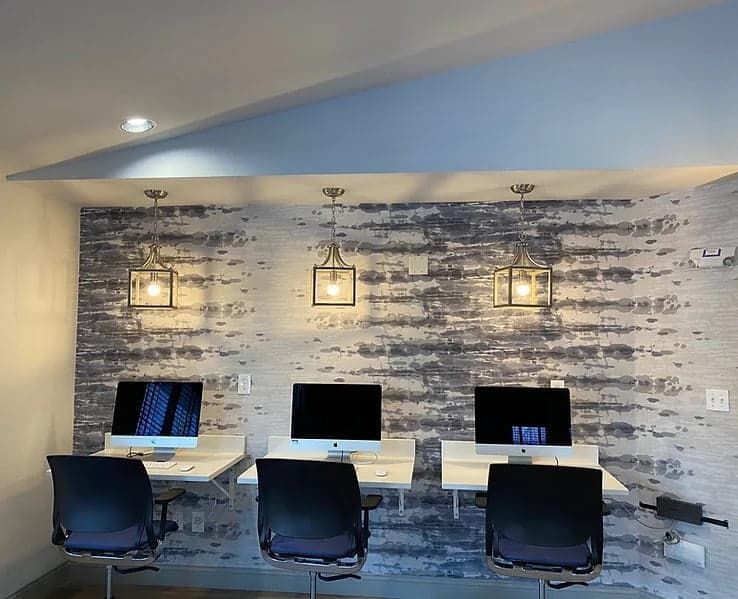 Office with a brick-look feature wall and pendant lights