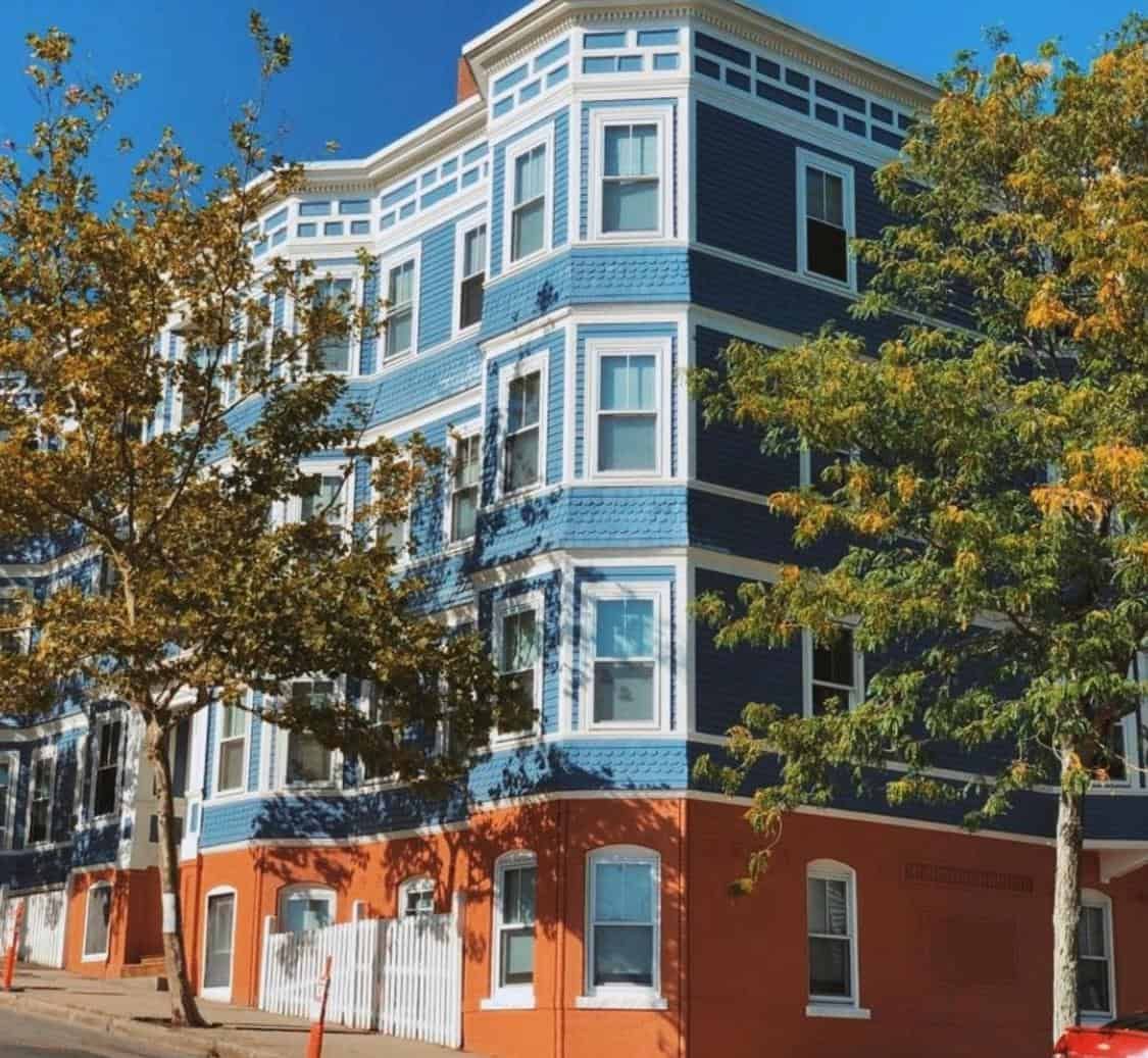 Three-story multi-family building painted blue and white